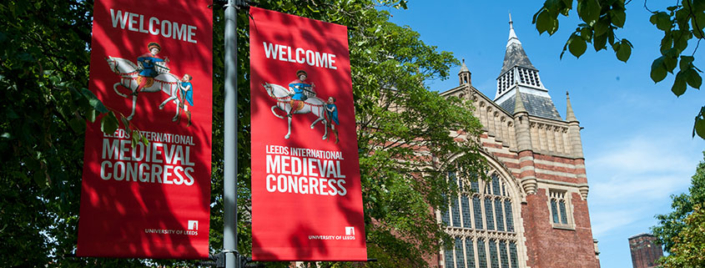 A photo of International Medieval Congress flags flying on the University of Leeds campus