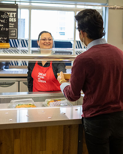 A member of the Refectory staff attending to a customer